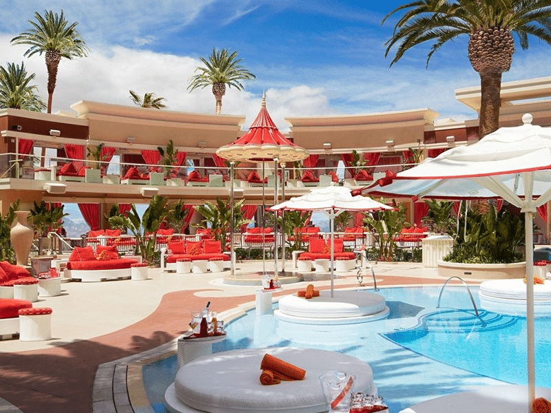 Encore Beach Club Las Vegas during the day, umbrella and seats are visible scattered throughout with cabanas on an upper balcony