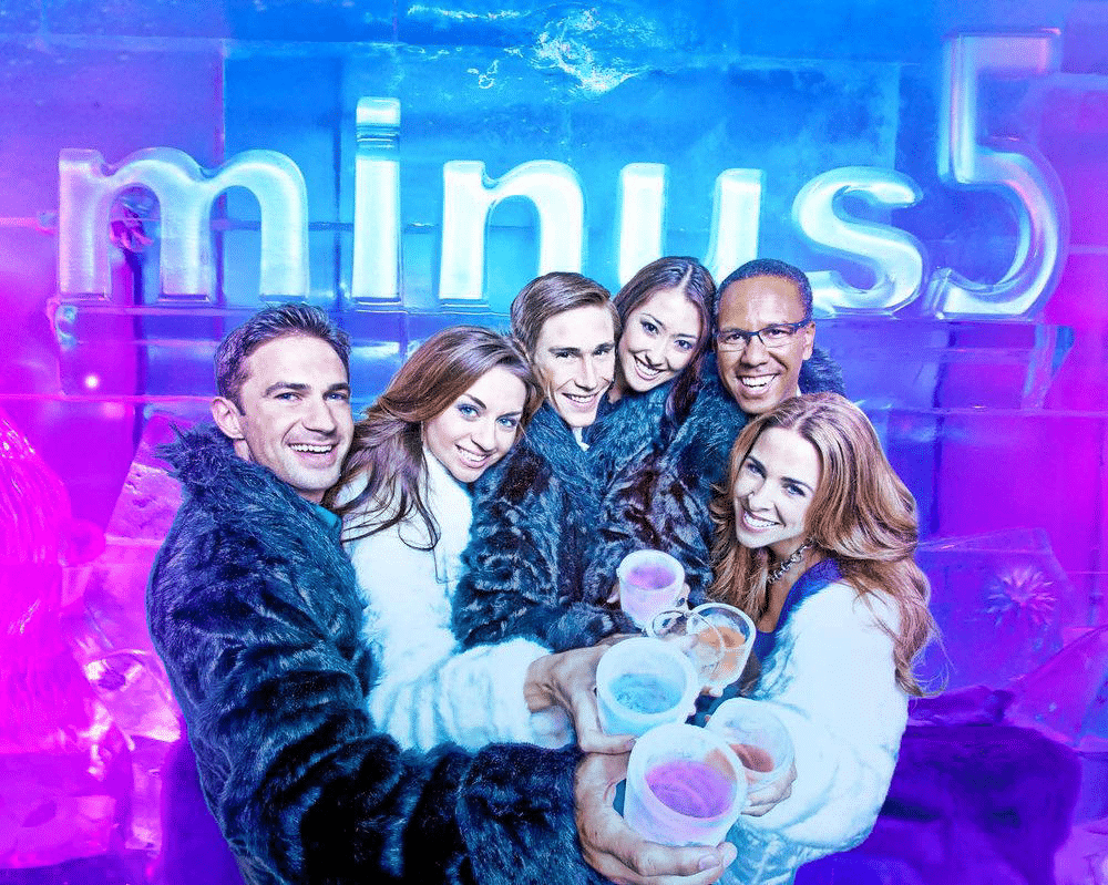 Group of people holding drinks and smiling at Minus5 Ice Bar Las Vegas