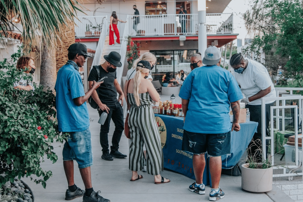 Group of people looking at salad dressings at Market in the Alley art show in Las Vegas